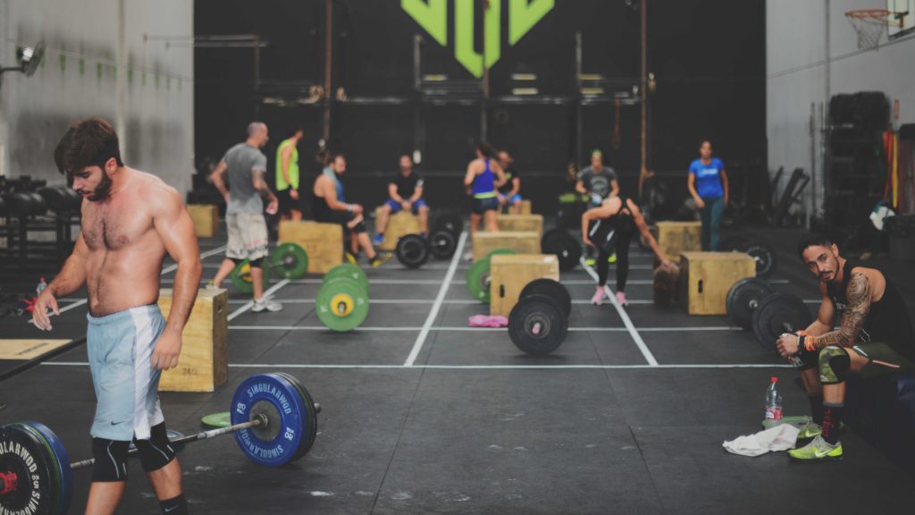 A busy CrossFit gym filled with athletes and barbells