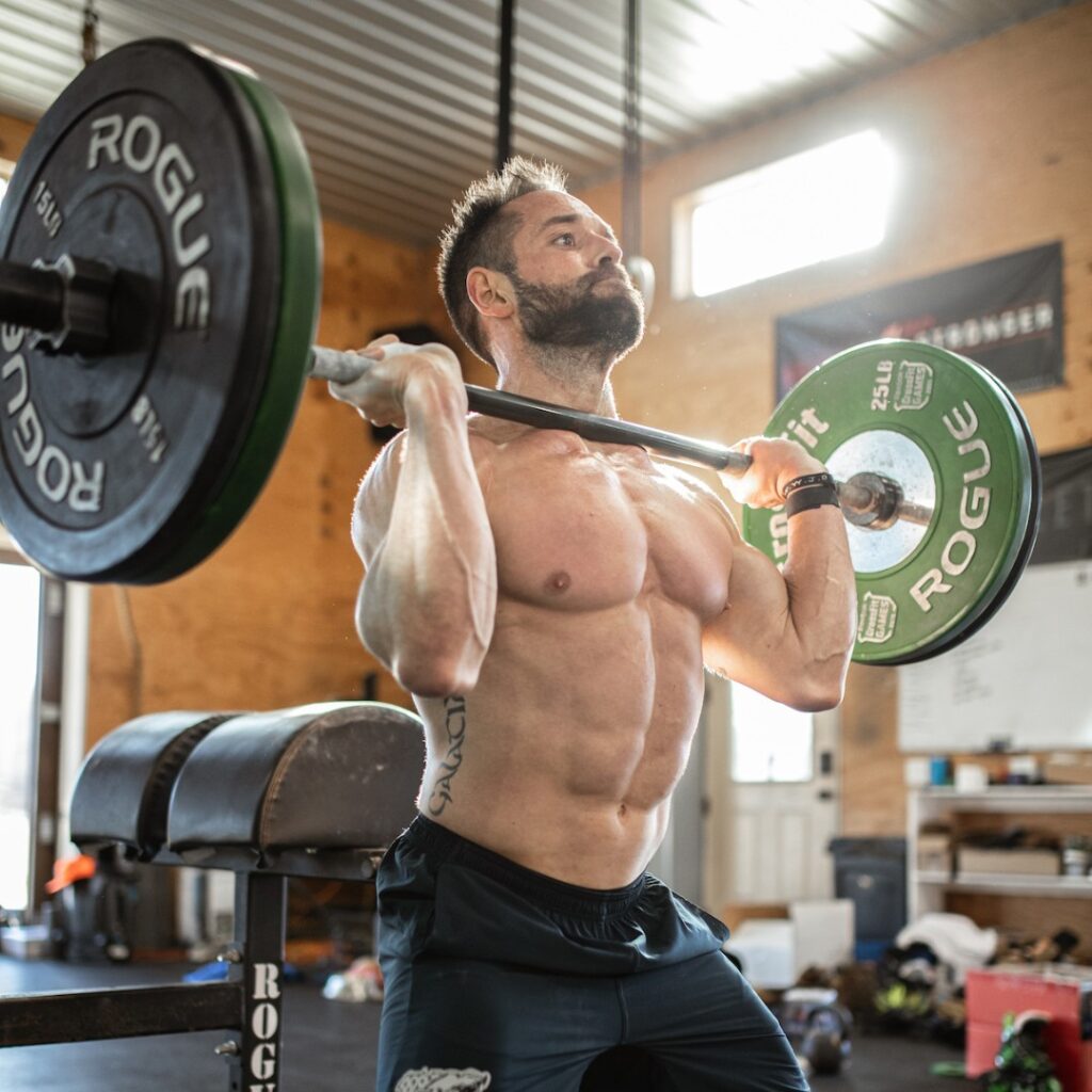Rich Froning demonstrating intense workout at his CrossFit gym, showcasing dedication and athleticism.